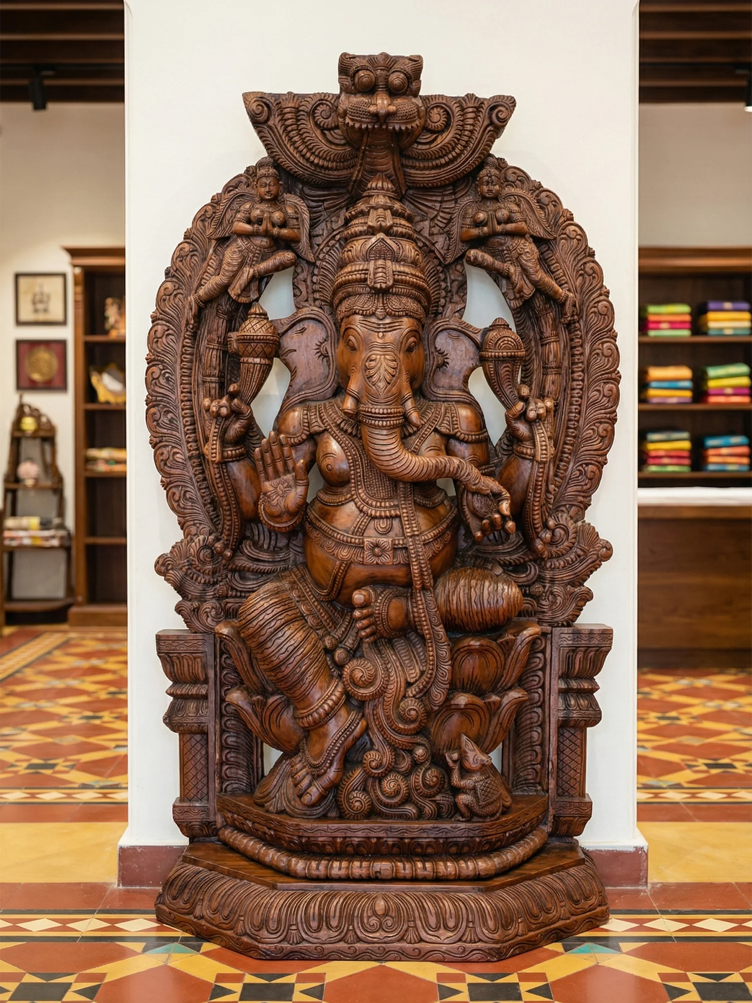 Carved wooden Ganesh statue of a deity in a decorative lotus setting
