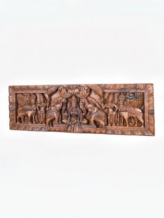 Elegant wooden Gajalakshmi carving with ornate temple border.