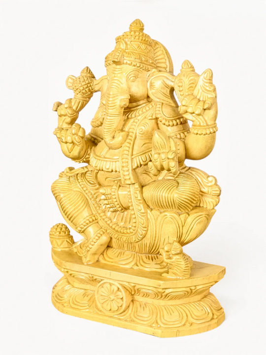 Hand-carved wooden Lord Ganesha statue seated on a lotus pedestal with intricate traditional Indian craftsmanship.