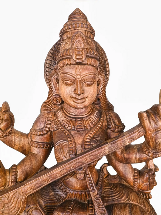 Wooden Saraswati sculpture crafted by skilled Indian artisans.