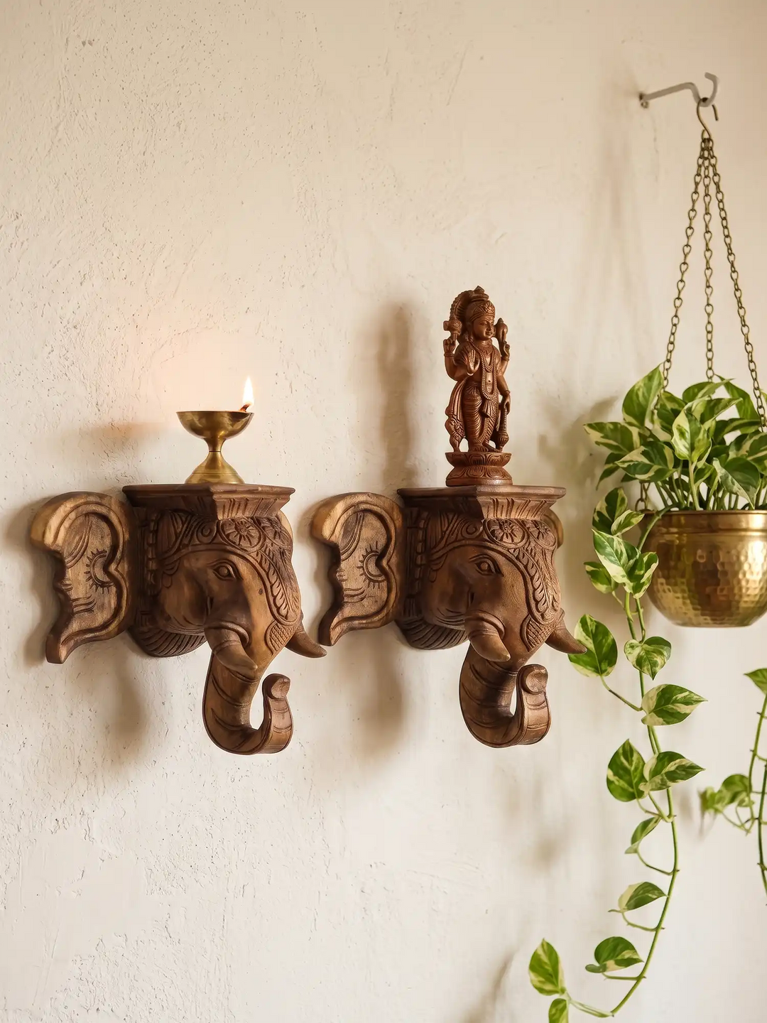 Pair of handcrafted wooden elephant head sculptures with stand