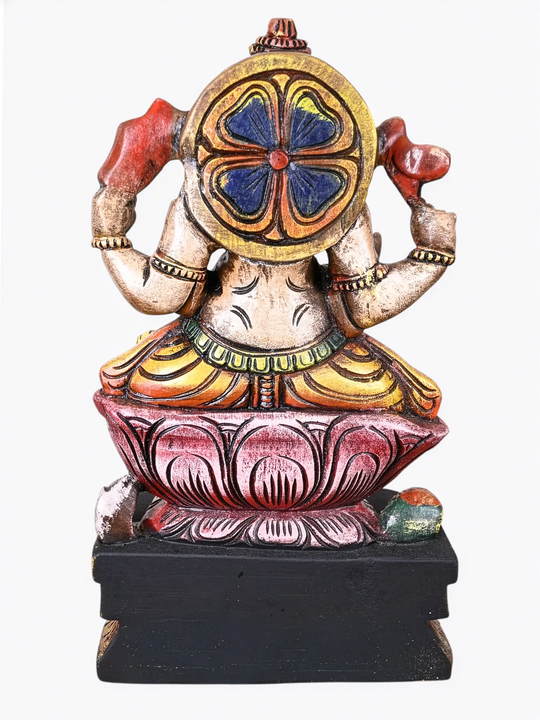 Hand-painted wooden Lord Ganesha idol seated on a pink lotus with vibrant traditional detailing.
