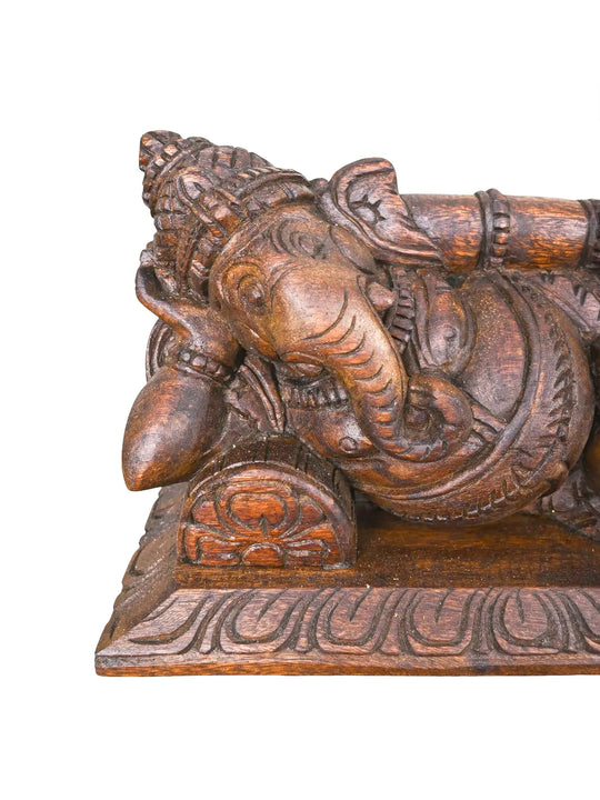 Wooden spiritual decor featuring reclining Lord Ganesha.