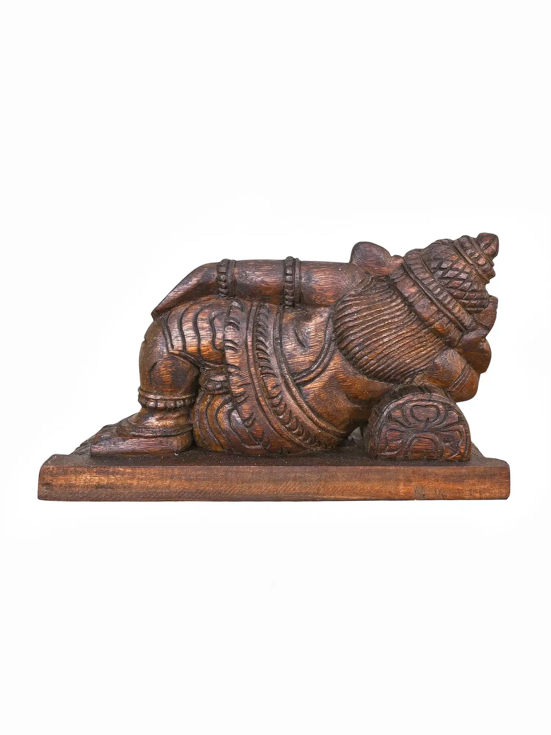Wooden sleeping Ganesha sculpture with intricate temple carvings.
